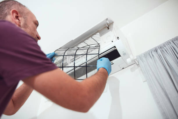 istock Man cleaning and maintaining air condition unit at home. 2184111553