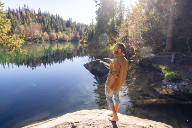 istock Man Enjoying Tranquility by Forest Lake 2184113296