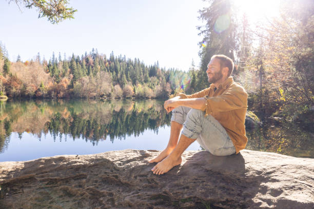 istock Man Relaxing by Scenic Forest Lake 2184113375