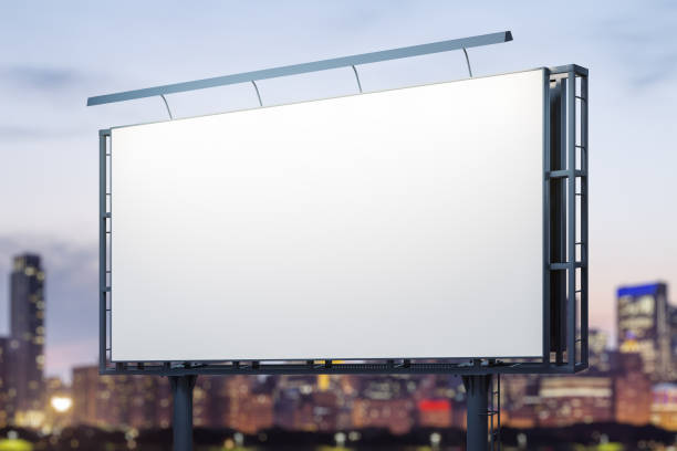istock Blank white billboard on cityscape background at evening, perspective view. Mock up, advertising concept 2184114486
