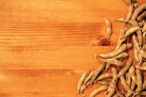 Ripe soybean pods on wooden desk, top view
