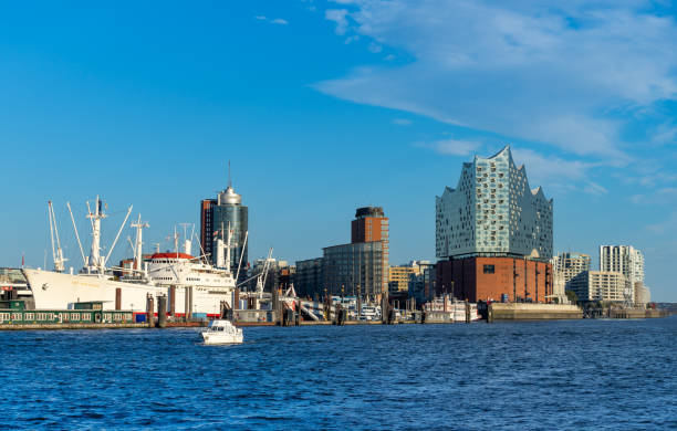 Hamburg iconic harbor area, featuring a vibrant red lightship docked along modern architecture and bustling promenades. The scenic waterfront captures the city's maritime charm and lively atmosphere