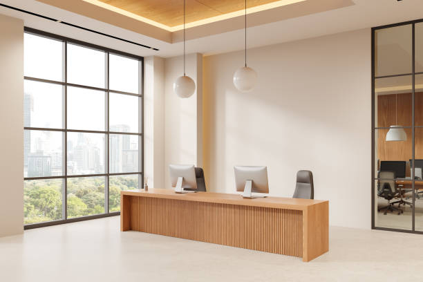 istock Modern open-space office with a wooden desk, two computers, and large windows overlooking a cityscape. Minimalist interior design with neutral tones. 3D Rendering 2184122608
