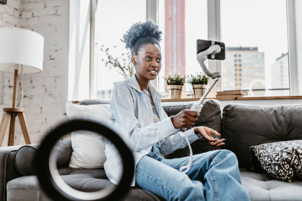 istock Confident Black Woman Vlogging with Smartphone at Home 2184123384