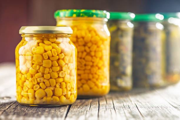istock Canned sweet corn in jar on wooden table. 2184125131