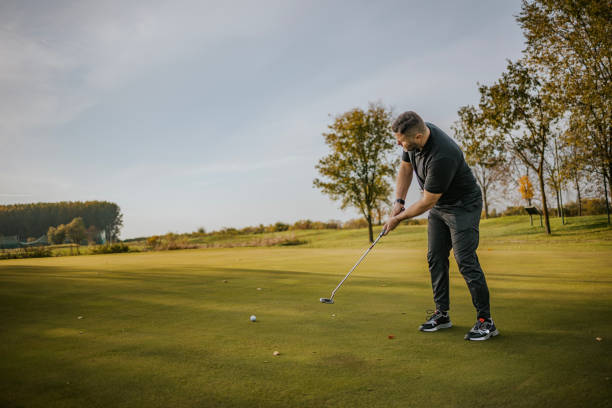 istock Man playing golf on a sunny day at a green golf course 2184125263
