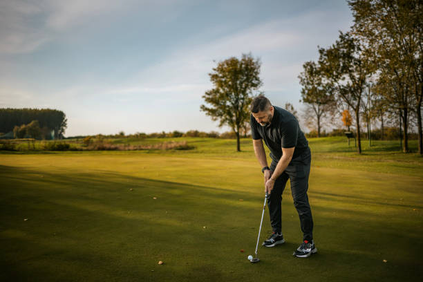 Man preparing to putt on a scenic golf course green