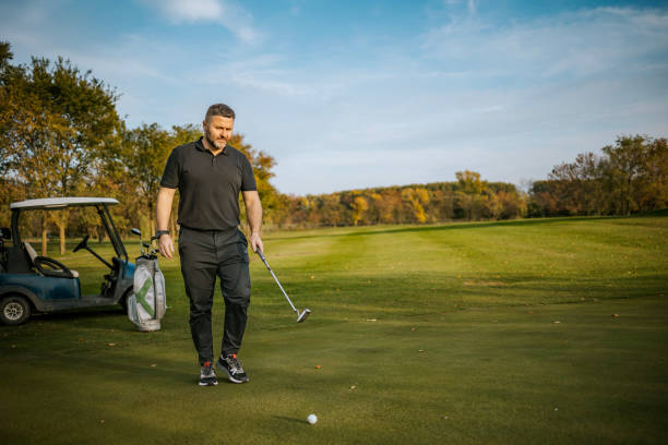 istock Man preparing for a golf putt on a scenic golf course 2184126123