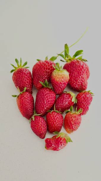 istock Top view shot of strawberries arranged in a neutral background. 2184127545
