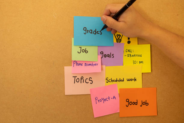 istock Male hand writing with a marker on a blue sticky paper on a board 2184132294