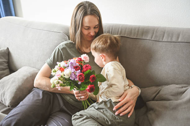 istock son congratulate mom on the holiday and give her flowers 2184132443