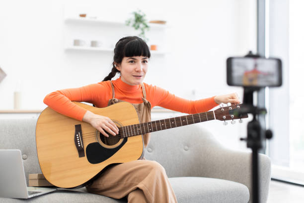 istock Caucasian female blogger recording guitar lesson at home studio setting 2184134747
