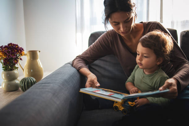 istock Mother and son reading the book at home 2184135112