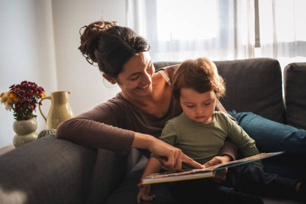 istock Mother and son reading the book at home 2184135345