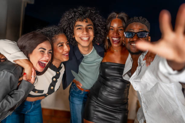 istock Happy friends joking while embracing in a night party 2184137549