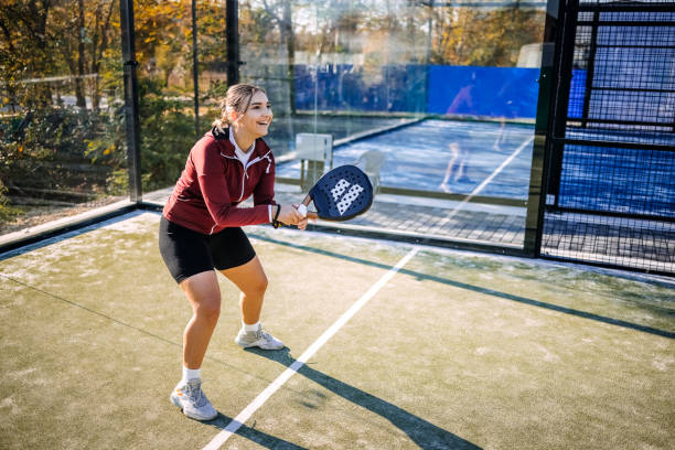 istock Young woman playing badel on sport court taking a shoot using racket 2184144082