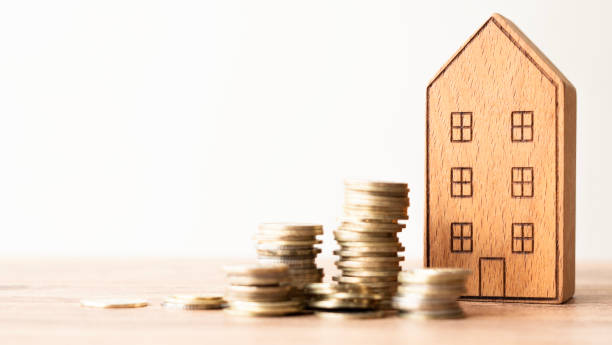 istock Real estate concept background. House model and coins stack on wooden table, copy space. 2184146748