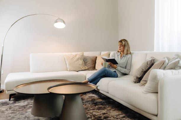 istock Senior woman reading book at home 2184147051