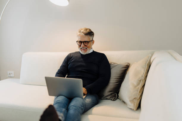 istock Mature adult man using laptop at home 2184147113
