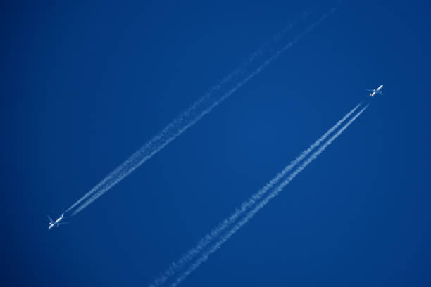 Airplanes in the blue sky with contrails. Shallow depth of field.