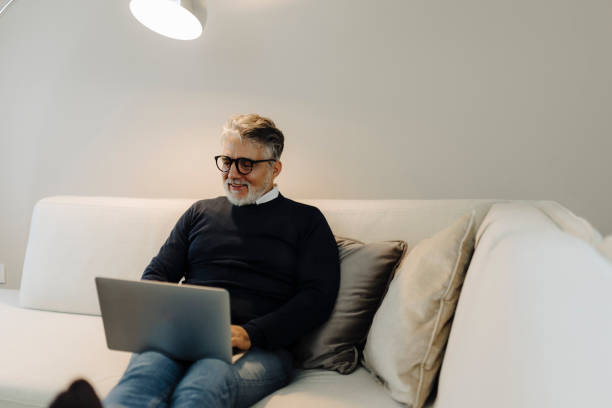 istock Mature adult man using laptop at home 2184148210