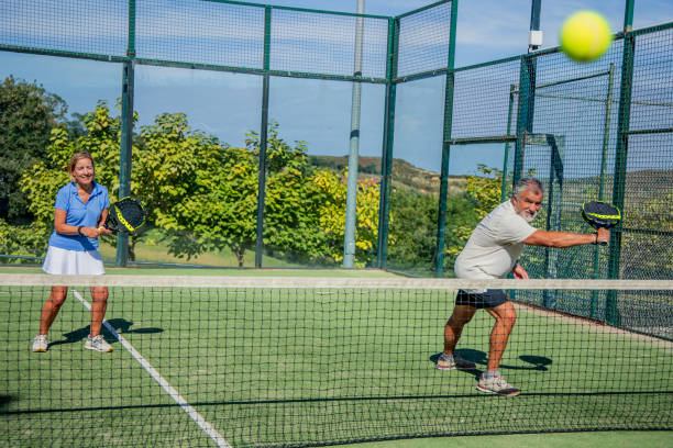 istock Senior padel player couple hitting ball toward camera during match 2184148215