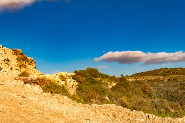 Serene photo capturing a Cypriot mountain vista with a clear sky, few clouds, and limited vegetation, showcasing the island's natural beauty