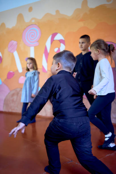 the  5-7 year old children at an acting class with their teacher, extracurricular activities