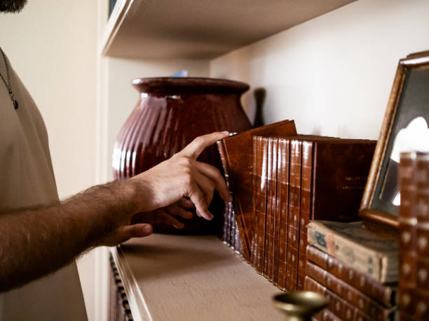 A person taking a vintage book from a shelf at home