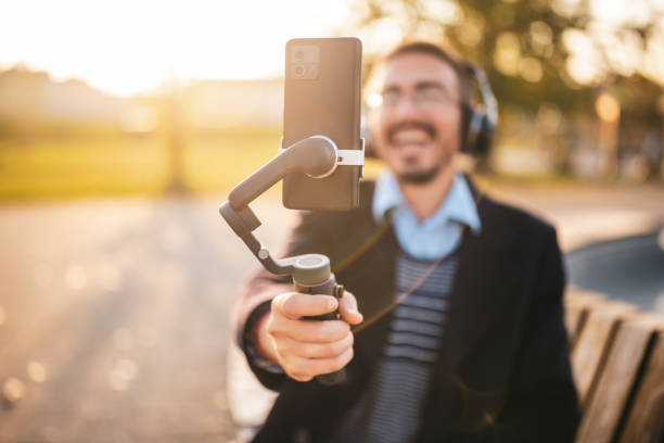 istock Cheerful businessman in coat vlogging outdoor 2184153909