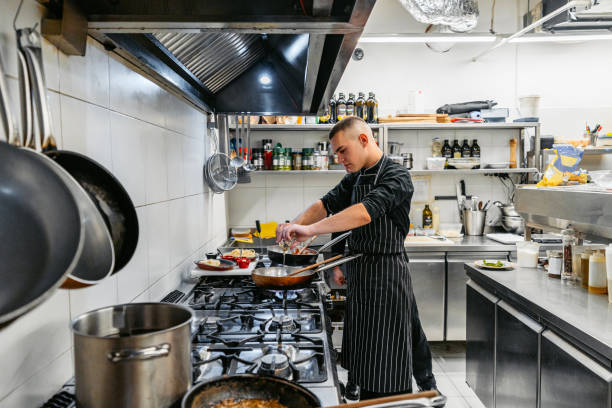 istock Chef And Sous-Chef Cooking With A Pan In A Commercial Kitchen 2184155395