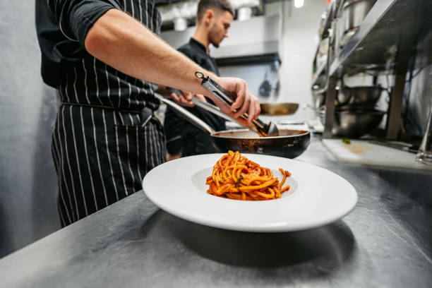 istock Chef And Sous-Chef Making Bolognese Pasta In A Commercial Kitchen 2184155800