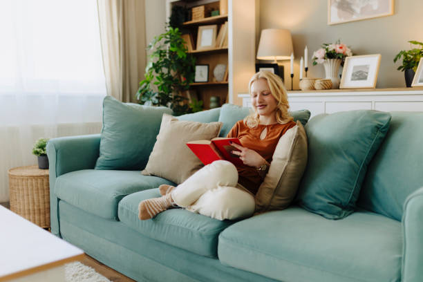 istock Young albino woman reading book at home 2184160109
