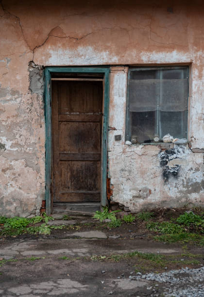 istock Weathered door and vintage window on abandoned building 2184160341