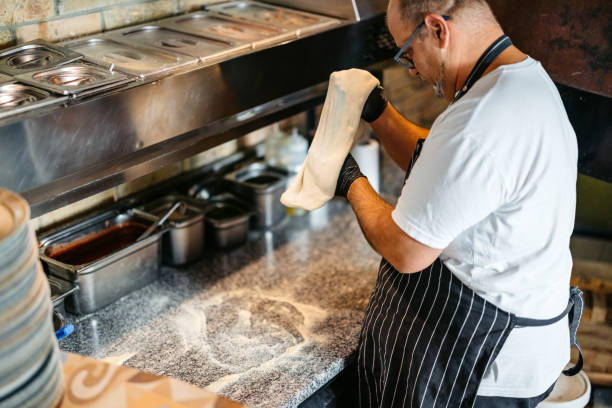 istock Mature Chef Making Pizza Dough In A Commercial Kitchen 2184160371