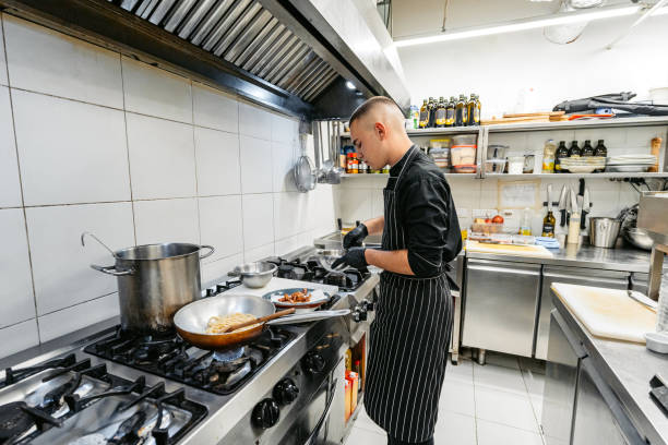 istock Young Chef Cooking With A Pan In A Commercial Kitchen 2184162122