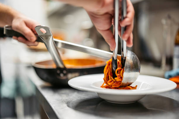 istock Young Chef Making Bolognese Pasta In A Commercial Kitchen 2184162365