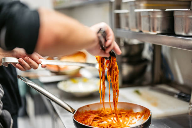 istock Young Chef Making Bolognese Pasta In A Commercial Kitchen 2184162664