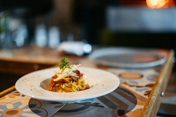 Close-up view of spaghetti with carbonara sauce. Typical Roman recipe with eggs, bacon, pecorino romano and parmesan. Typical Italian food and recipes