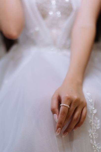 istock Bride's hand with pearl ring on lace dress. 2184164042