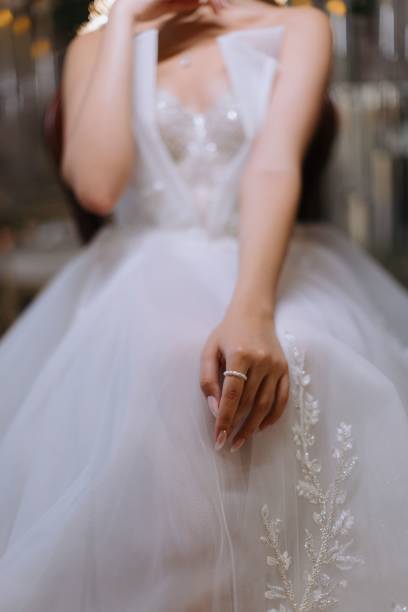 istock Bride's hand on lace wedding gown 2184164079