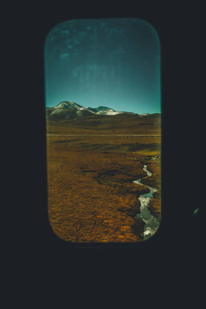 looking through train window scenery in tibet snow capped mountain rural scene