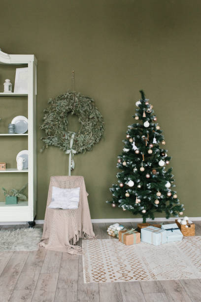 istock Christmas tree in the room with a wreath on the green wall 2184166296