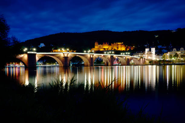 The old bridge and castle reflected in the Neckar River at night. Heidelberg, Germany. October 1, 2024