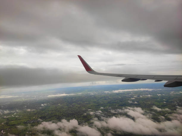 The airplane wing on the sky with dark rain cloud.