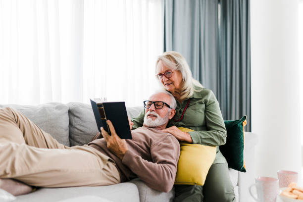 istock Sernior couple reading book and resting at home 2184168498