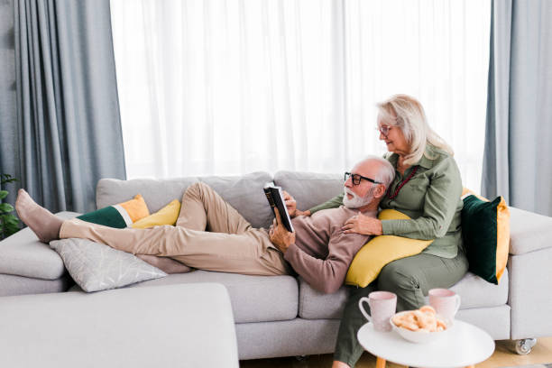 istock Sernior couple reading book and resting at home 2184168663