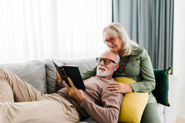 istock Sernior couple reading book and resting at home 2184169683