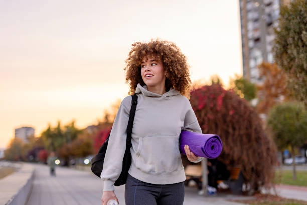 istock Content woman carrying yoga mat with scenic backdrop 2184170928