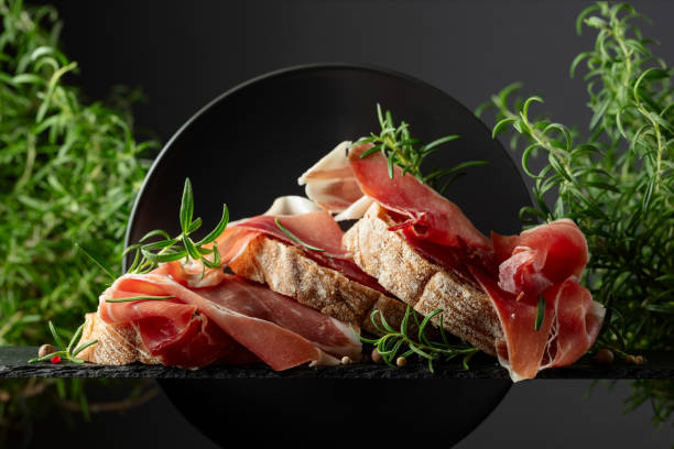 istock Ciabatta with prosciutto and rosemary on a black background. 2184171296